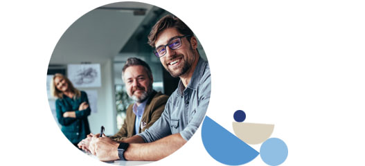 tres personas en la oficina sentados y sonrientes mirando a cámara