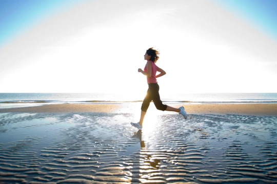 Chica corriendo por la playa